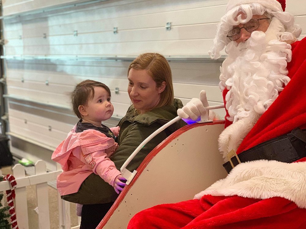 Lottie and Mummy stood looking up at Santa on his sleigh