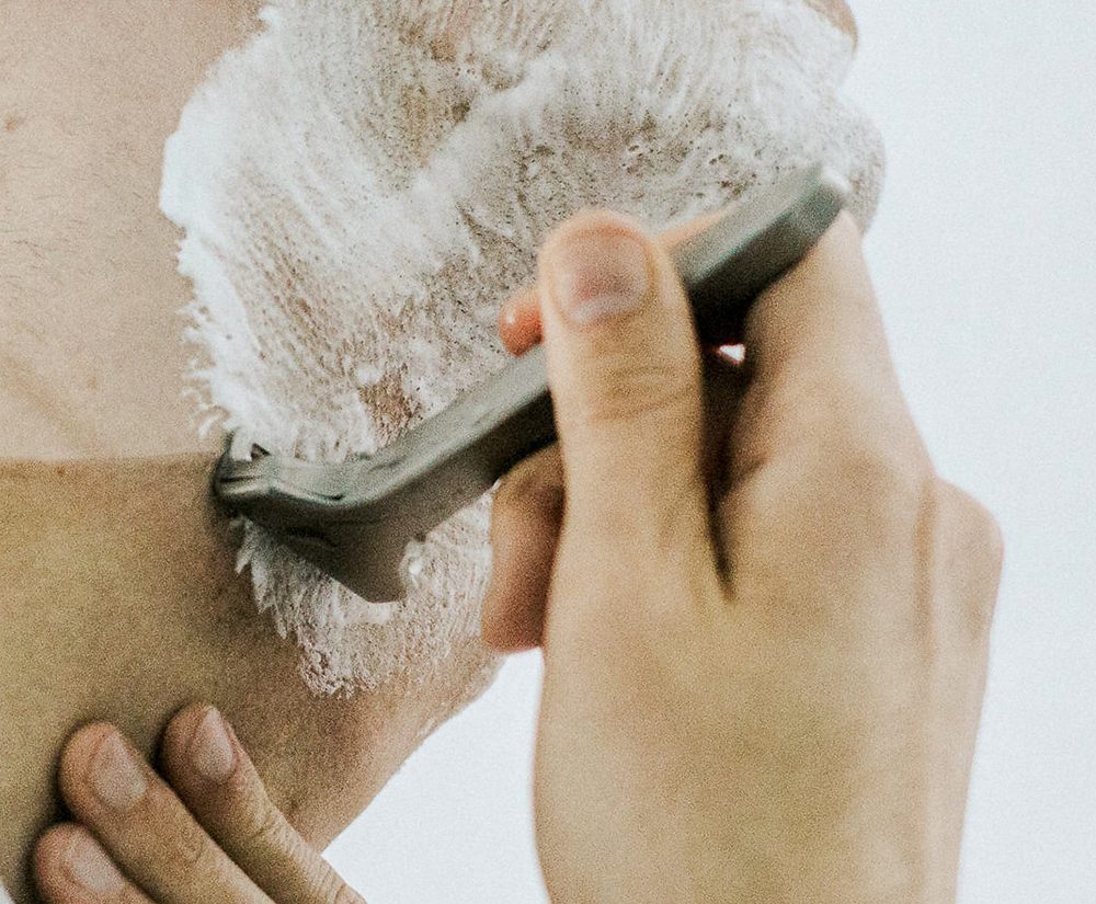 Man shaving his face with a razor