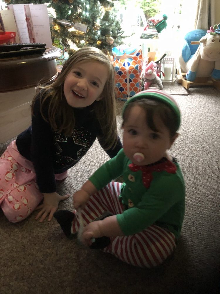 Lottie dressed as an elf and Lottie sat in front of the christmas tree