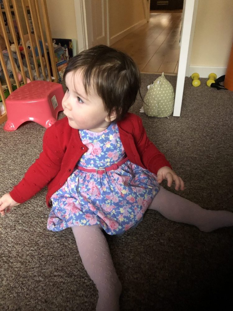 Lottie dressed in a pretty flowery dress turned away from the camera