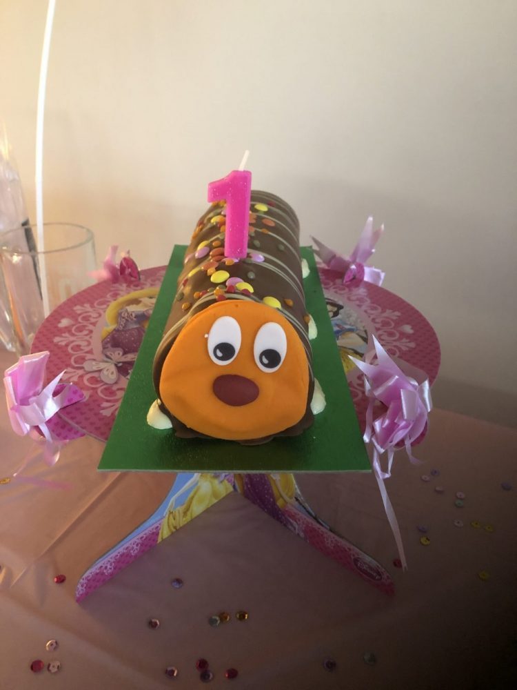 Curly the Caterpillar cake with the number 1 candle on it