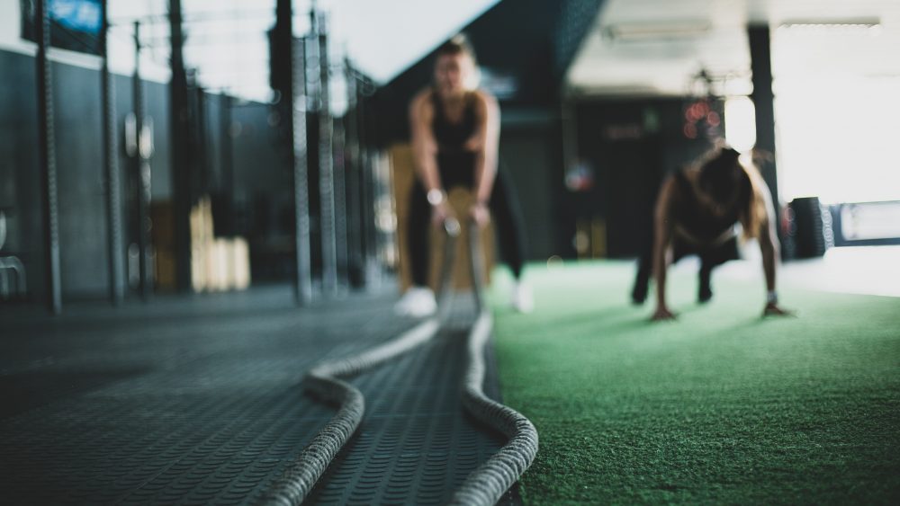 2 blurred people working out at the gym