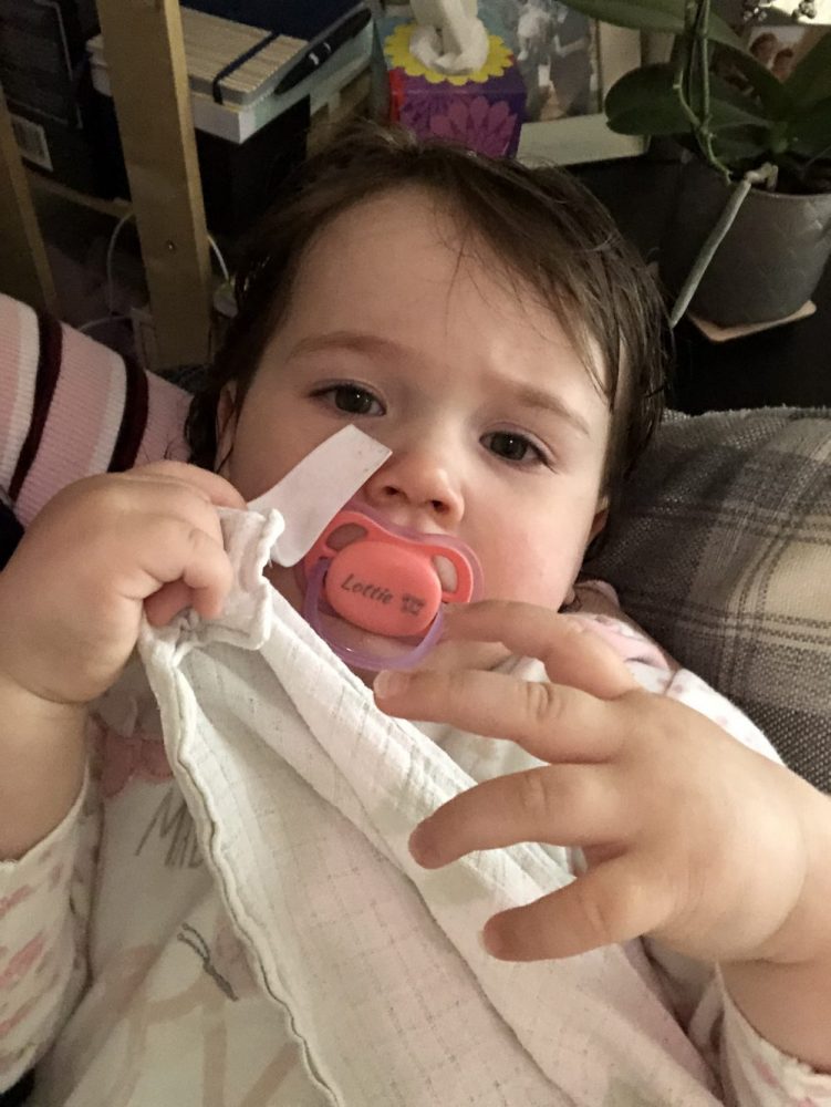 Lottie with her personalised dummy, holding a muslin cloth